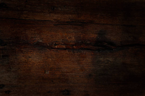 Old worn, weathered, dark, teak wood panel. Distressed, old, teak wood panel with lots of texture and character for use as a background. brown university stock pictures, royalty-free photos & images