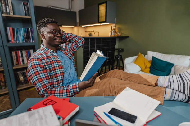istock African-American man reading a book at home 1368760991