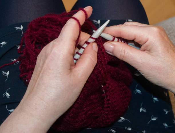 istock women knitting with dark red wool 1368769659