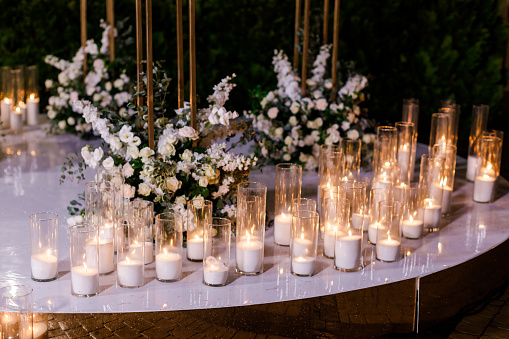 Night wedding ceremony with a lot of lights, candles, lanterns. Beautiful romantic shining decorations in twilight