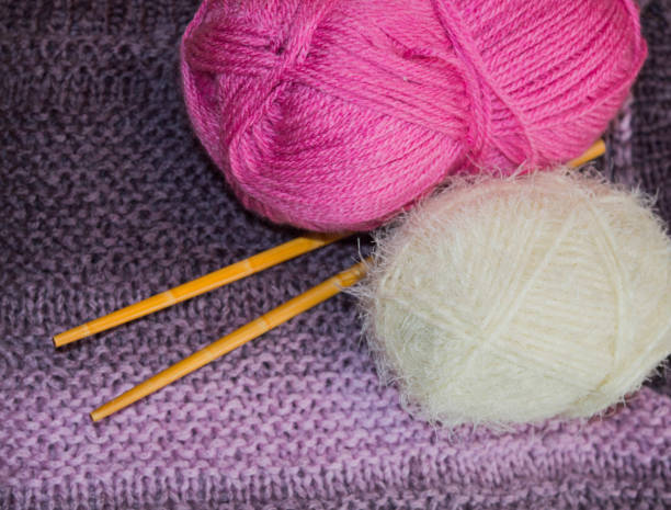 istock pink and white woolen ballst with knitting needles on a knitted scarf 1368771297