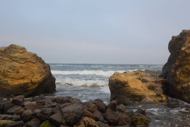 istock Black sea behind two big yellow shell rocks 1368773261
