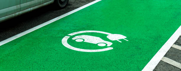 Empty electric vehicle charge station parking spot, marked green zone, car charging device symbol on the asphalt, nobody. Eco, environmentally friendly cars, means of transport, transportation lugar de estacionamiento vacío de la estación de carga de vehículos eléctricos, zona verde marcada, símbolo del dispositivo de carga del automóvil en el asfalto, nadie. coches ecológicos, respetuosos con el medio ambiente, medios de transporte, tran