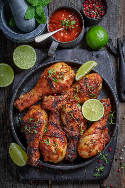 istock Hot roasted chicken leg served with lime and sauces. 1368779105