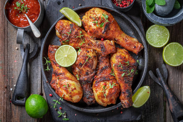 istock Spicy roasted chicken leg served with lime and sauces. 1368779132