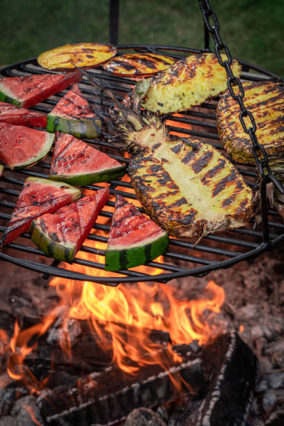 istock Hot roasted watermelon and pineapple on grill grate with fire. 1368780216