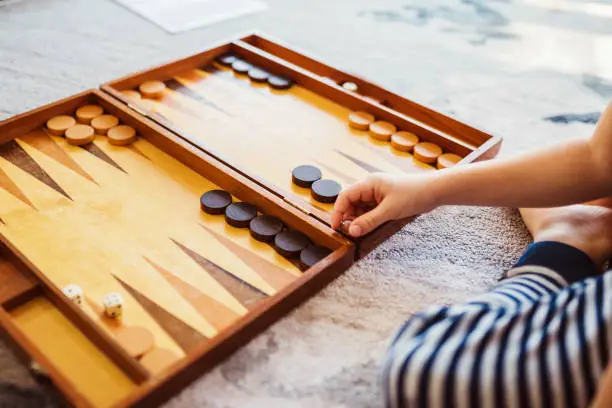 Boy learns to play backgammon - rolls dice