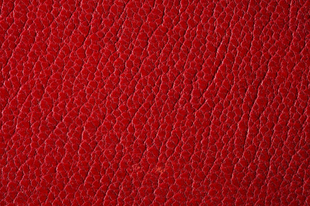 Seamless 4k photo texture photo of black colored leather material with brass rivets and colored stitched belts.