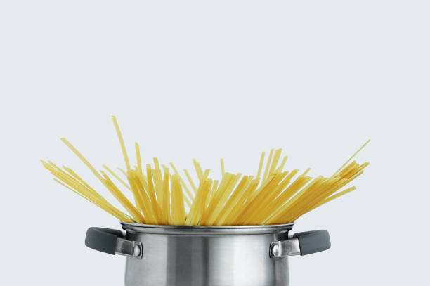 istock Yellow pasta in gray metal pan. White background. 1368784257