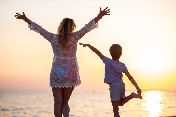 istock Mam and son watching a sunset on the beach 1368785362