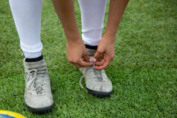 Teenage girls binding shoelaces at the same time