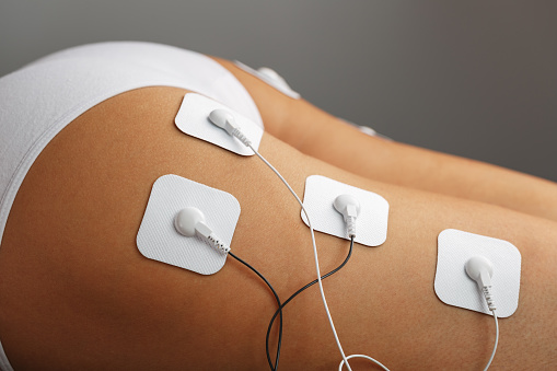 Myostimulation electrodes on the buttocks and legs of a woman in a beauty salon. Rehabilitation and treatment, weight loss.