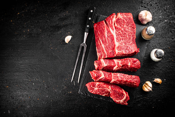 istock Pieces of raw beef on a stone board. 1368790439