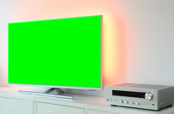 istock Large backlit green screen LED TV with audio receiver in a modern apartment. 1368791306