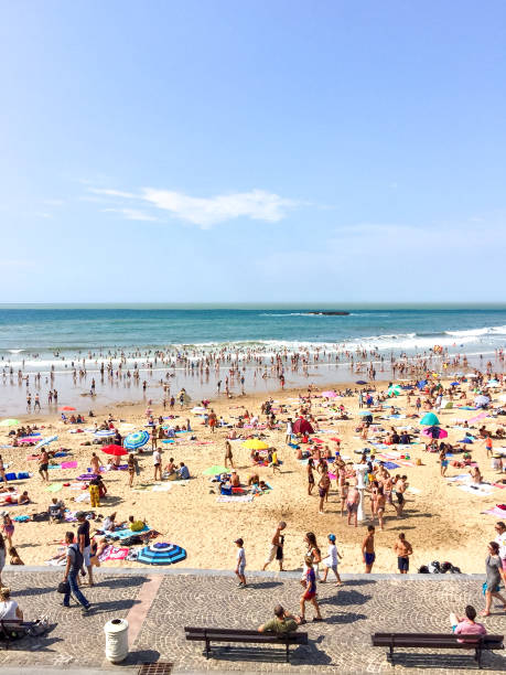 Crowded public beach “La Grande Plage” in Biarritz, France. Atlantic ocean coast, sand beach, summer. French Basque Country