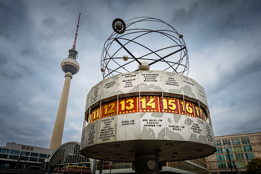 Berlin, Germany - August 10, 2018: Alexanderplatz station sign with Berliner Fernsehturm television tower in the background.