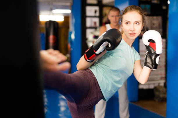 istock Woman kicking punchbag 1368796132