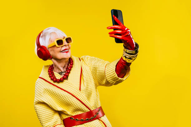 Cool and stylish senior old woman with fashionable clothes Happy and funny cool old lady with fashionable clothes portrait on colored background - Youthful grandmother with extravagant style, concepts about lifestyle, seniority and elderly people funky stock pictures, royalty-free photos & images