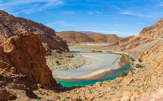 The turquoise blue of the ziz rive gorge is a stark contrast to the desert rock in the high Atlas Mountains of Morocco