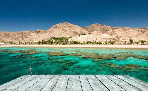 Coral reefs of the Red Sea and foreground of wooden footpath as a copy space for web banner