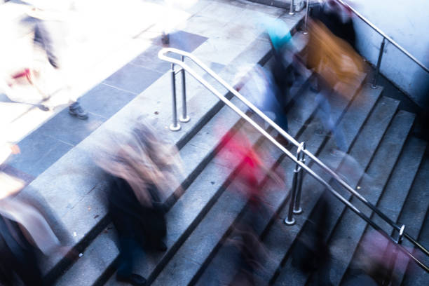 Blurred city background with people on stairs go up and down in the evening sunlight, presentation with copy space.
