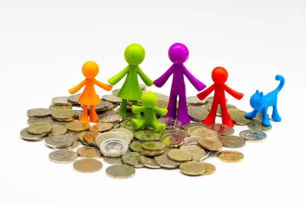 Photo of Colorful family figure made of silicone in various coins on white background