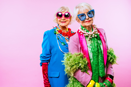 Happy and funny cool old ladies with fashionable clothes portrait on colored background - Youthful grandmothers with extravagant style, concepts about lifestyle, seniority and elderly people
