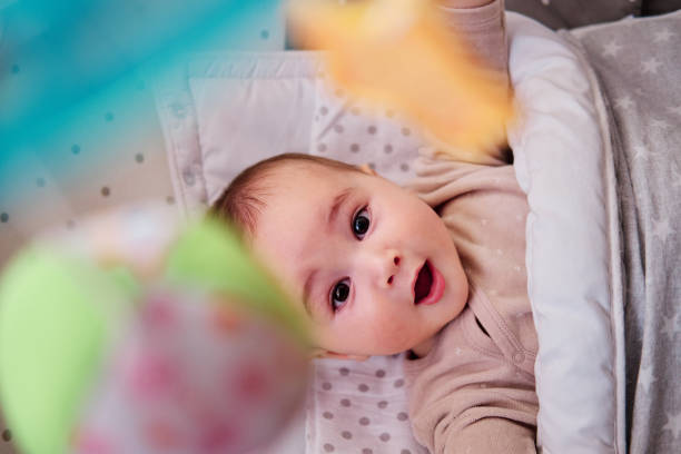 istock Baby playing with musical crib mobile 1368800913