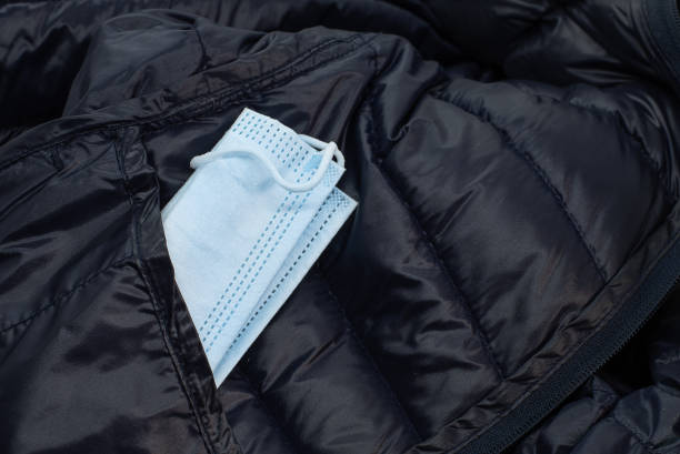istock blue face mask tucked in a pocket on a blue down jacket 1368803423