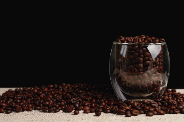 istock Roasted coffee beans in glass against black background 1368803595
