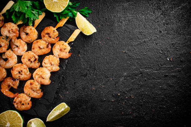 istock Grilled shrimp on a stone board with parsley and lime. 1368807232