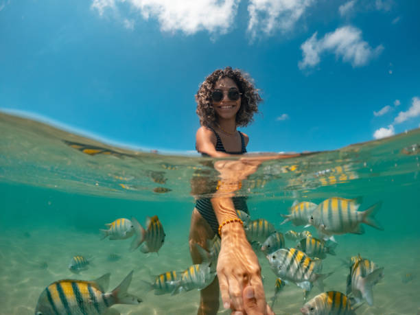 istock Young woman holding hands on tropical beach 1368808469