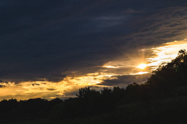 istock hillside silhouette partially covering the cloudy sky at sundown 1368809889