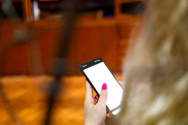 Layout for graphic designers. Unrecognizable person is holding a phone with white screen.