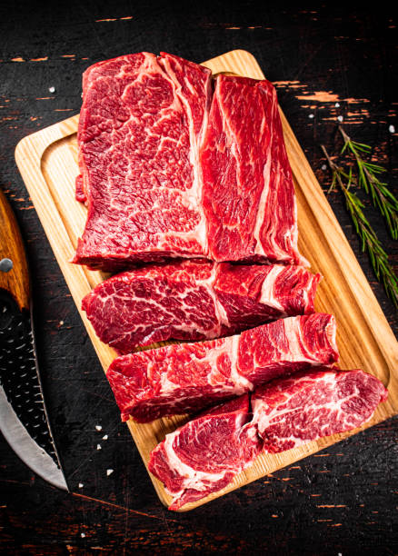 istock Raw beef on a wooden cutting board with rosemary. 1368815026