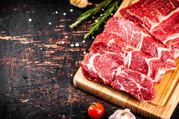 istock Raw beef on a wooden cutting board with rosemary. 1368815754
