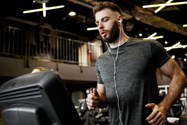 istock Young man running on a treadmill in gym 1368818697