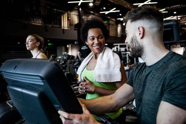 istock Smiling African American Woman with personal trainer on a treadmill getting ready for training 1368818926