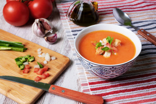 ガスパチョ、トマト、ニンニク、コショウ、タマネギをベースにアンダルシアの典型的な冷たいスープ。白い木製の背景に。 - plate blue dishware white ストックフォトと画像