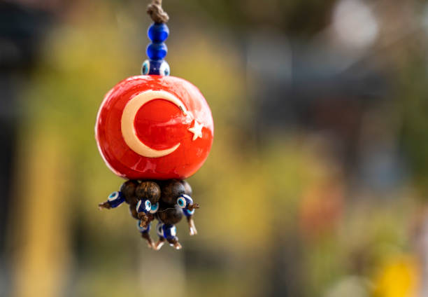 handmade evil eye beads with turkish flag on it, hung on a tree branch in garden - evil eye beads imagens e fotografias de stock