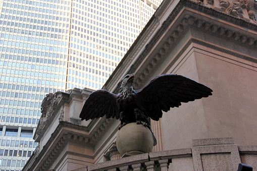 Sculpture of the American Eagle over the corner entrance of the Grand Central at Vanderbilt Avenue and East 42nd Street, iconic architectural detail, MetLife Skyscraper in the background, New York, NY, USA