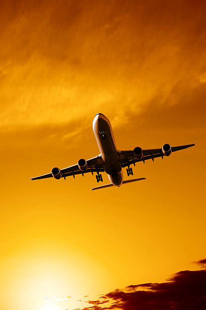 istock jet airplane landing at sunset 136882658