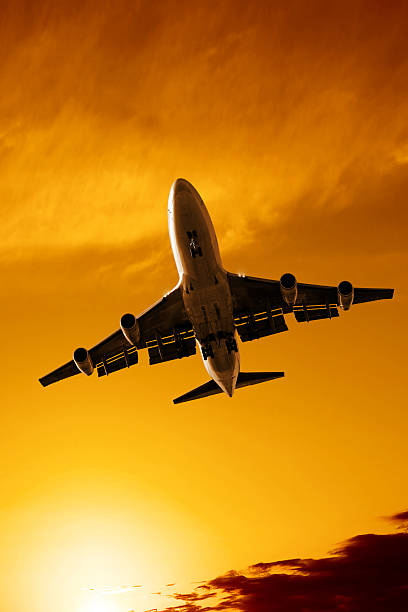 istock jumbo jet airplane landing at sunset 136882711
