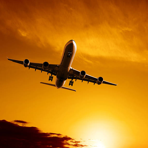 istock jet airplane landing at sunset 136882733