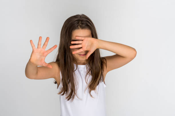 kind mädchen schließen die augen von hand - stop child stop sign child abuse stock-fotos und bilder