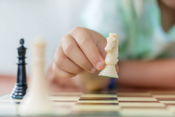 Young white child playing a game of chess on large chess board.