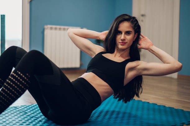 istock Beautiful young woman doing pushups while training at home 1368830709