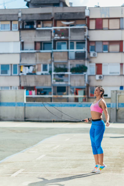 istock Attractive young woman using a fitness jump rope while training outside 1368830748