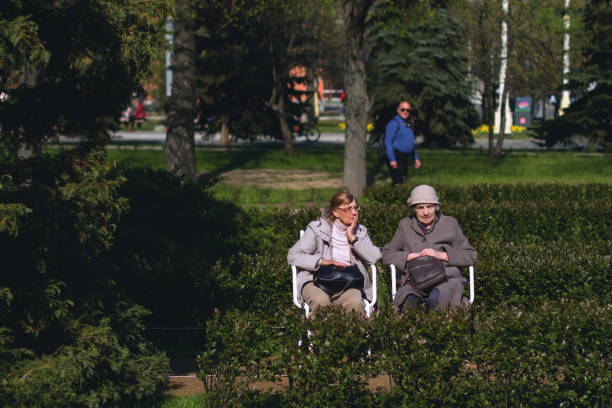 VDNH Park. Two elderly women are talking on a park bench stock photo