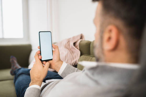 istock Man relaxing at home and using smartphone 1368843589